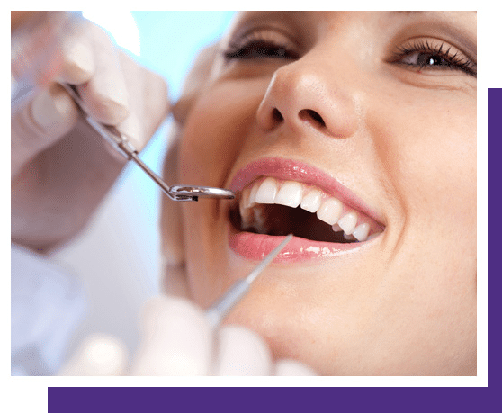 Dentist examining patient's teeth with dental mirror during oral checkup appointment.