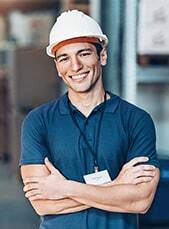 Smiling male dental professional in hard hat and blue uniform at Niceville dental practice.
