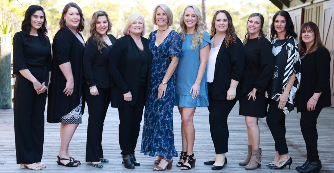 Dental practice team of ten women standing together outdoors in Niceville, Florida.
