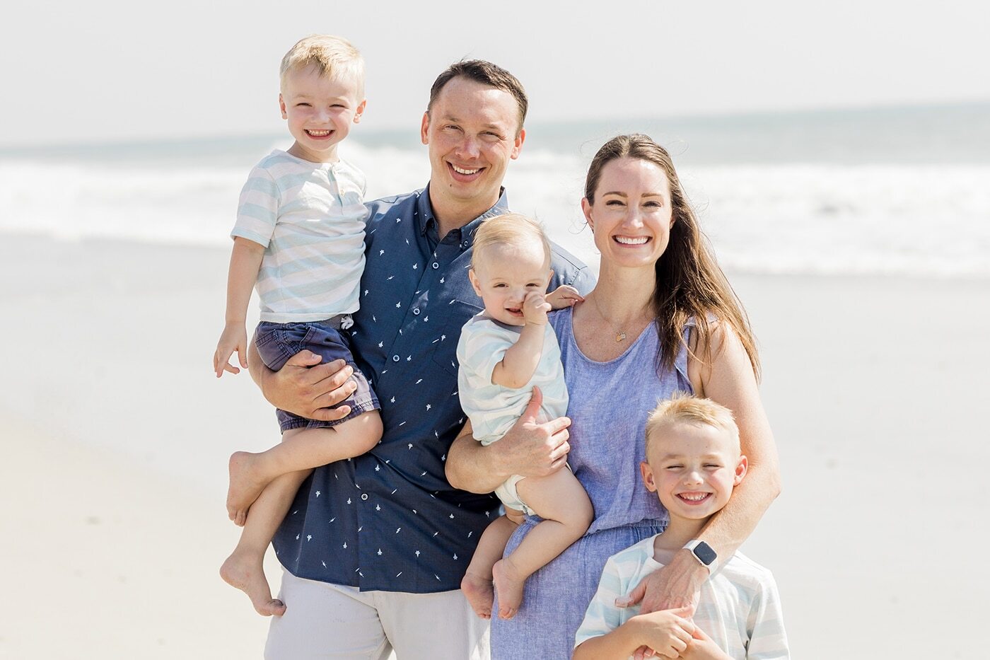 Happy family of five smiling at the beach in Niceville, Florida.