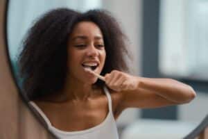 lady brushing teeth after tooth extraction
