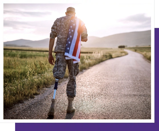 Military veteran with prosthetic leg running on rural road with American flag.