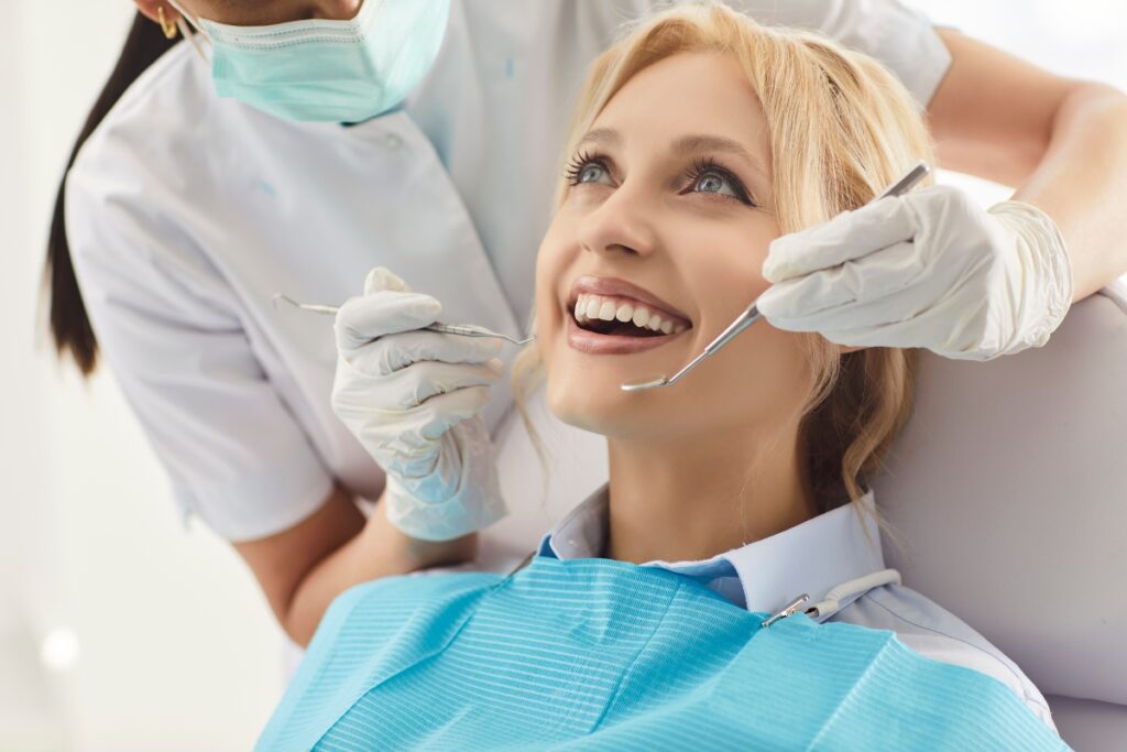 Dentist examines patient's teeth during dental checkup in clinical office setting.