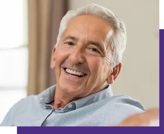Smiling older man with healthy teeth in blue shirt, Niceville airway treatment patient.
